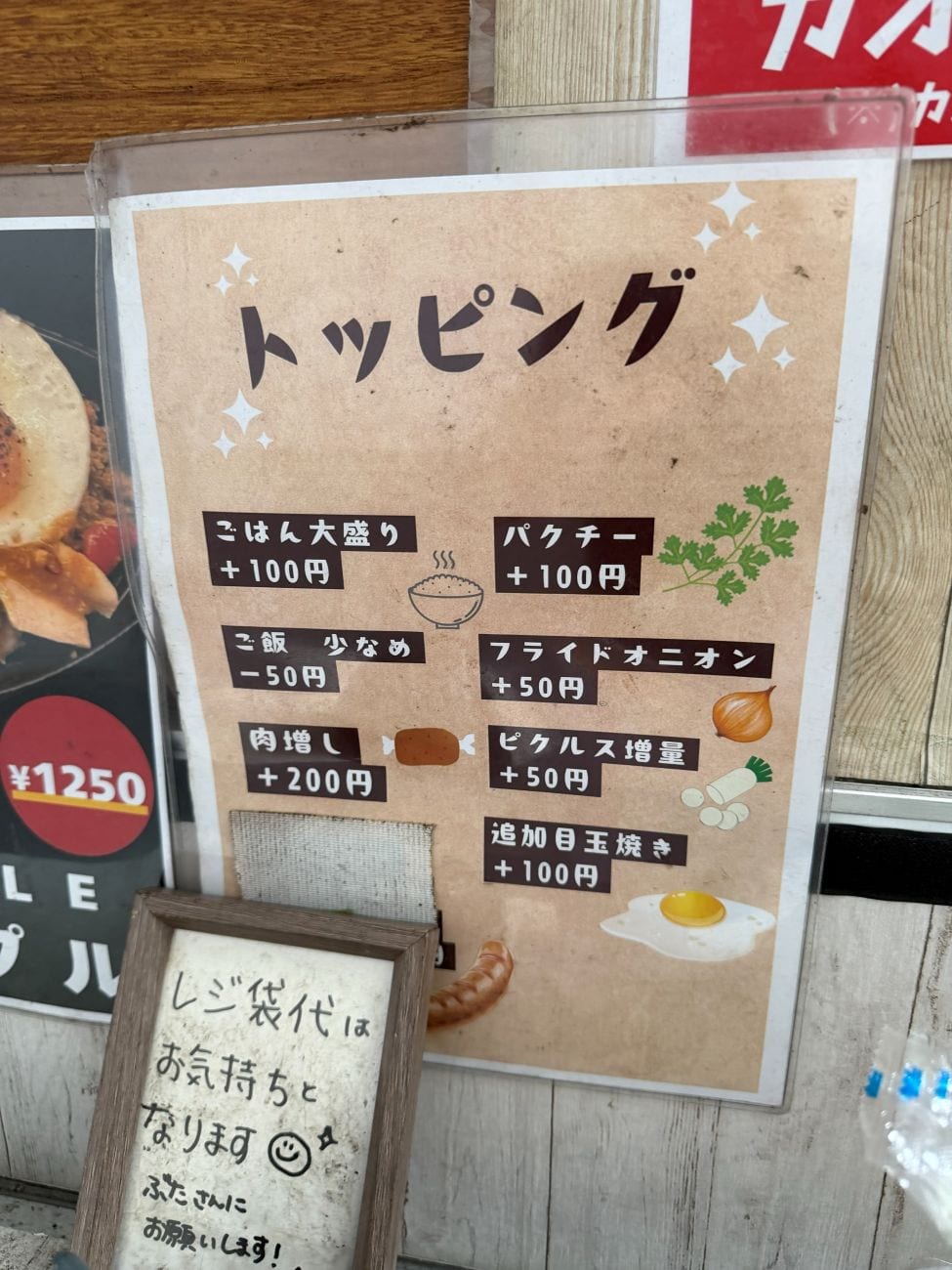 DAINIC_topping_menu.jpg/alt「DAINICのトッピング一覧の看板(パクチー・肉増し・ごはんの量の調整など)